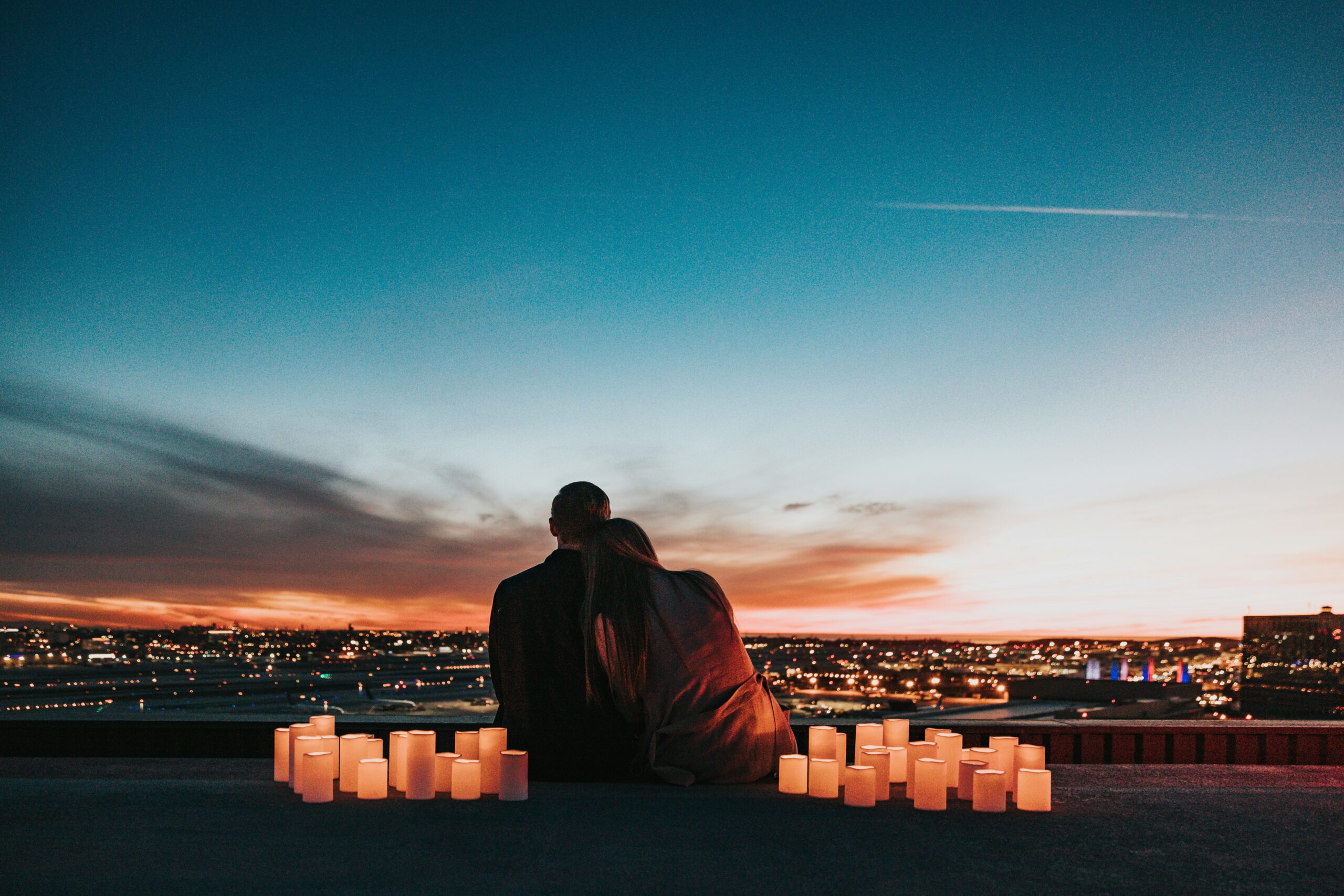 pareja sentada viendo el atardecer distanciada por el burnout